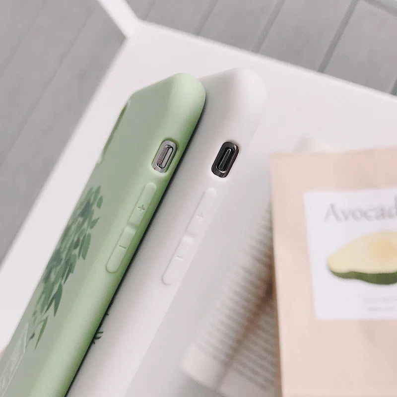 White silicone iPhone case with a detailed painted plant pattern on the back.