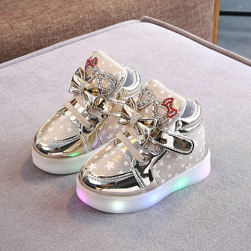 Children's LED magic button shoes with flashing lights in golden, pink, and silvery colours.