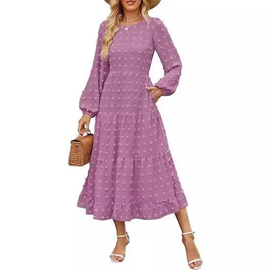 A woman wearing a beige high-waist long sleeve dress with ruffle detailing on the sleeves.