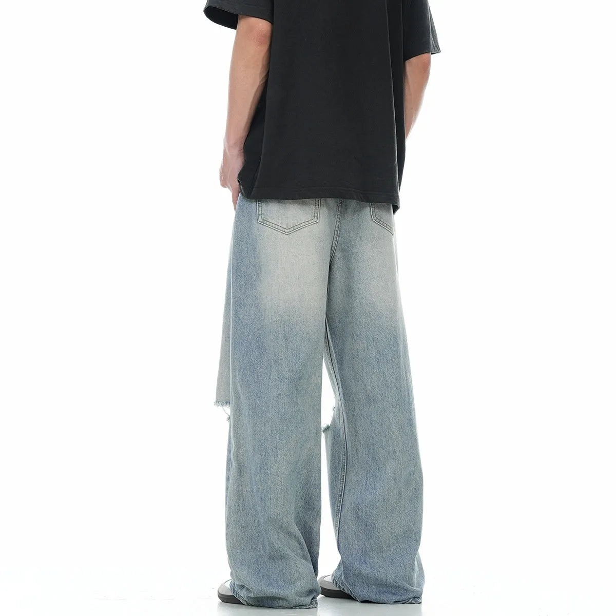 Blue men's straight-leg jeans with ripped detailing and a zip fly on a plain background.