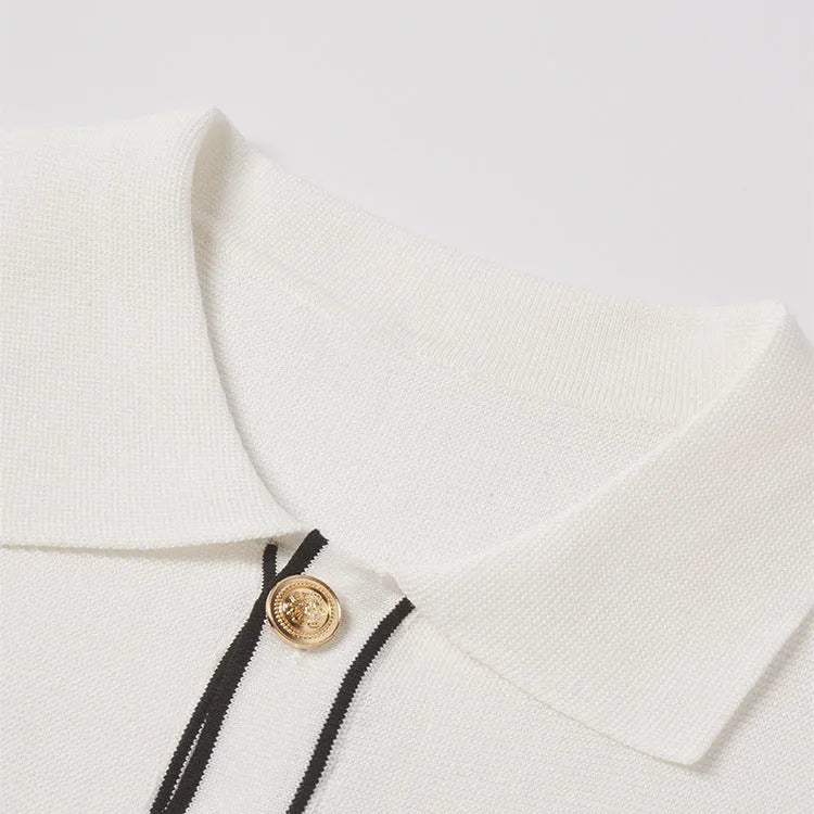 White short-sleeve cardigan with dark contrast colour lapels, laid flat to show front button detail.