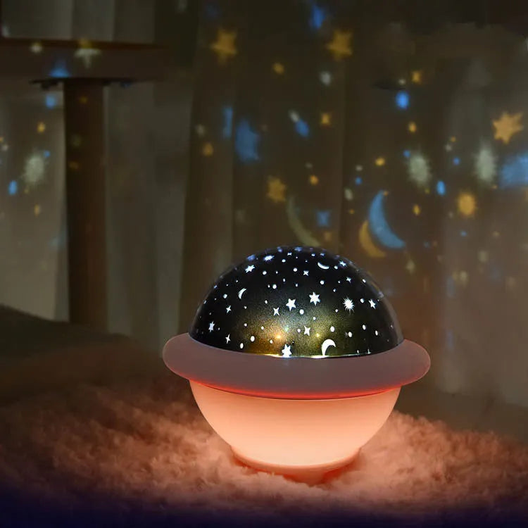 Green UFO-shaped plastic night light projecting a starry sky pattern onto a surface.