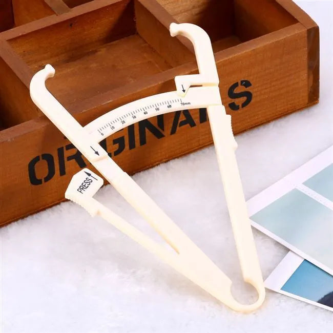 Clear acrylic body fat caliper skin fold thickness measuring instrument on a white background