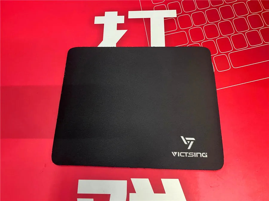 Black rough grain rubber desk mat for keyboard and mouse, shown on a desk
