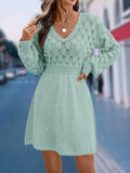 A high-waisted, long-sleeve v-neck dress with a 3D pattern in a light blue green colour.