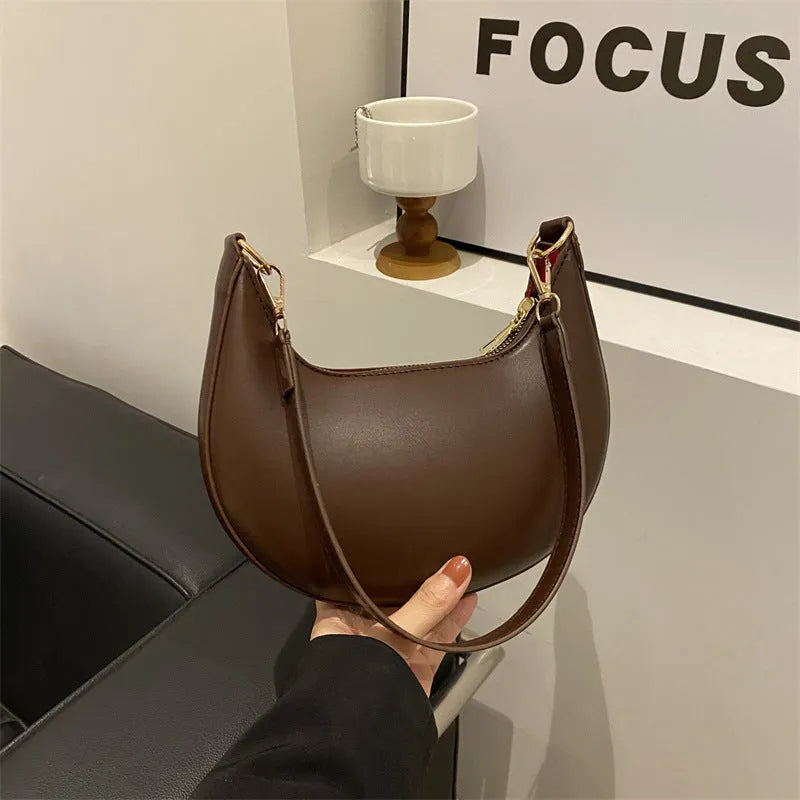 Round green one-shoulder underarm bag with visible sewing lines and sandwich-style compartments