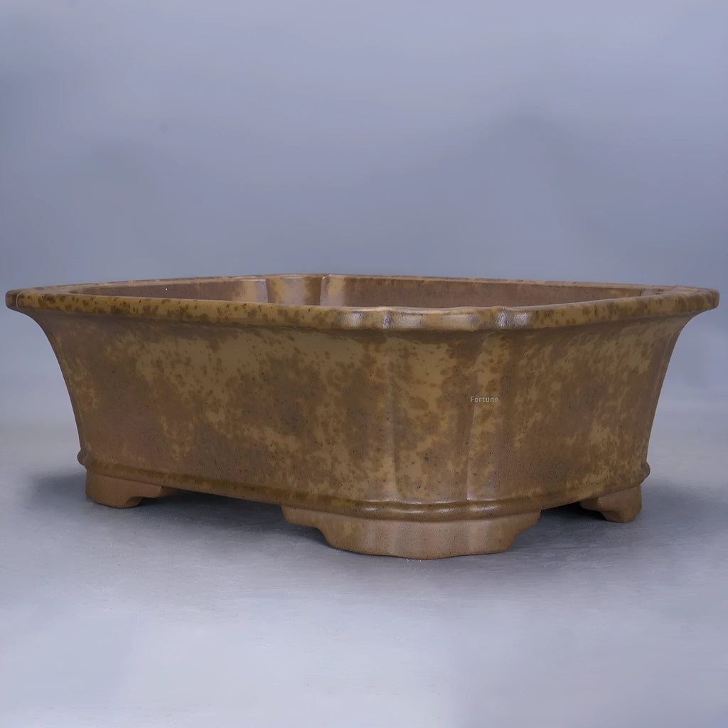 Large rectangular purple sand flowerpot with angled drainage base on a wooden patio.