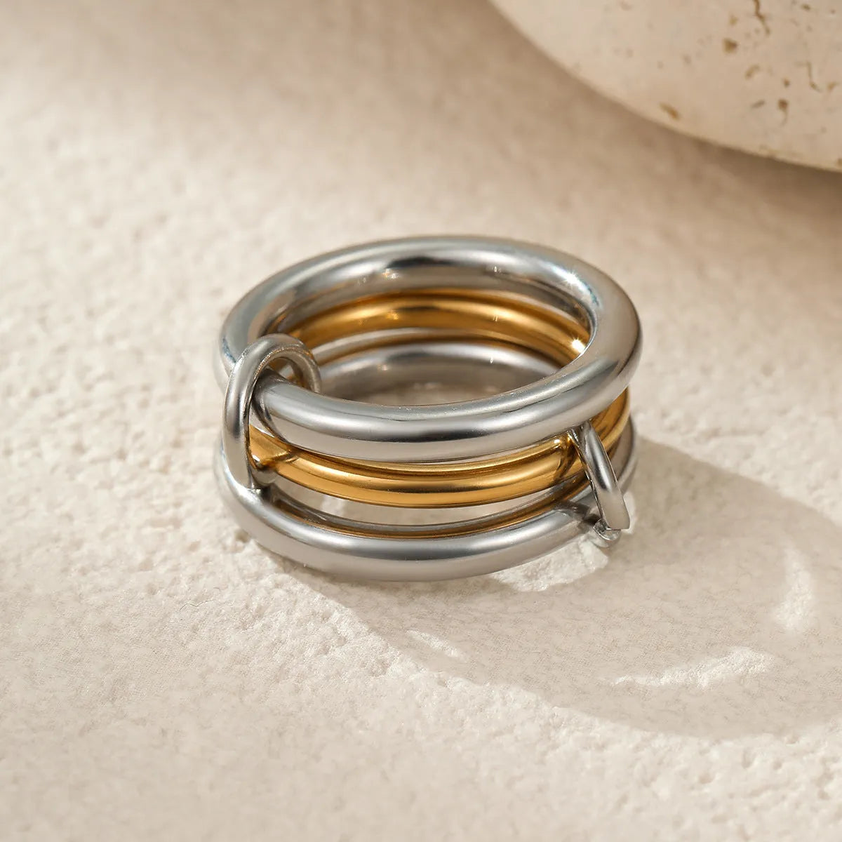 Stacked stainless steel rings with 18K gold plating in multiple colour options on a woman's hand.