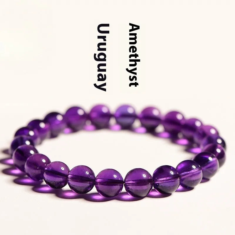 Loose polished amethyst beads on an elastic cord, forming a natural Uruguay crystal bracelet in violet shades.