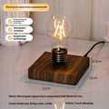 Small black suspension bulb desk lamp with iron art body on a wood grain base.