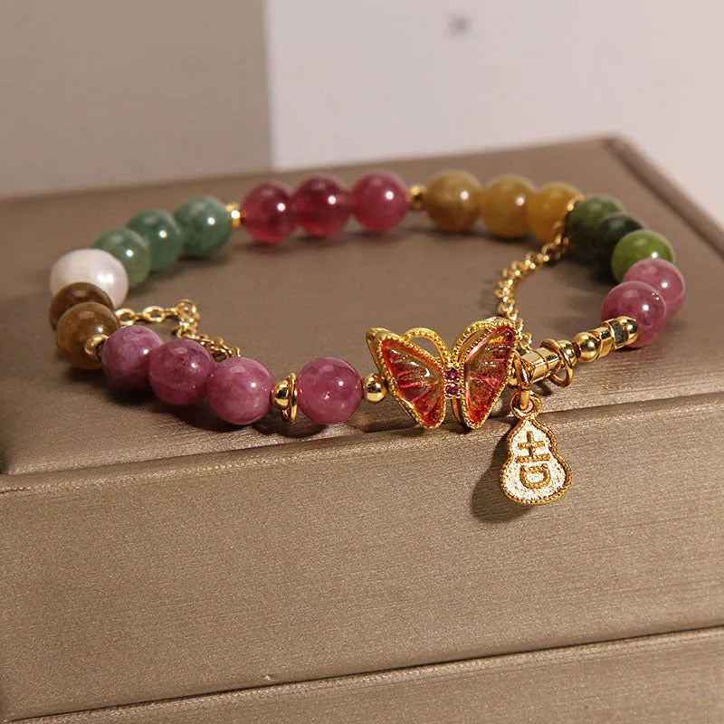 Natural jade coloured agate bracelet with a butterfly gourd tourmaline charm on an elasticated cord.