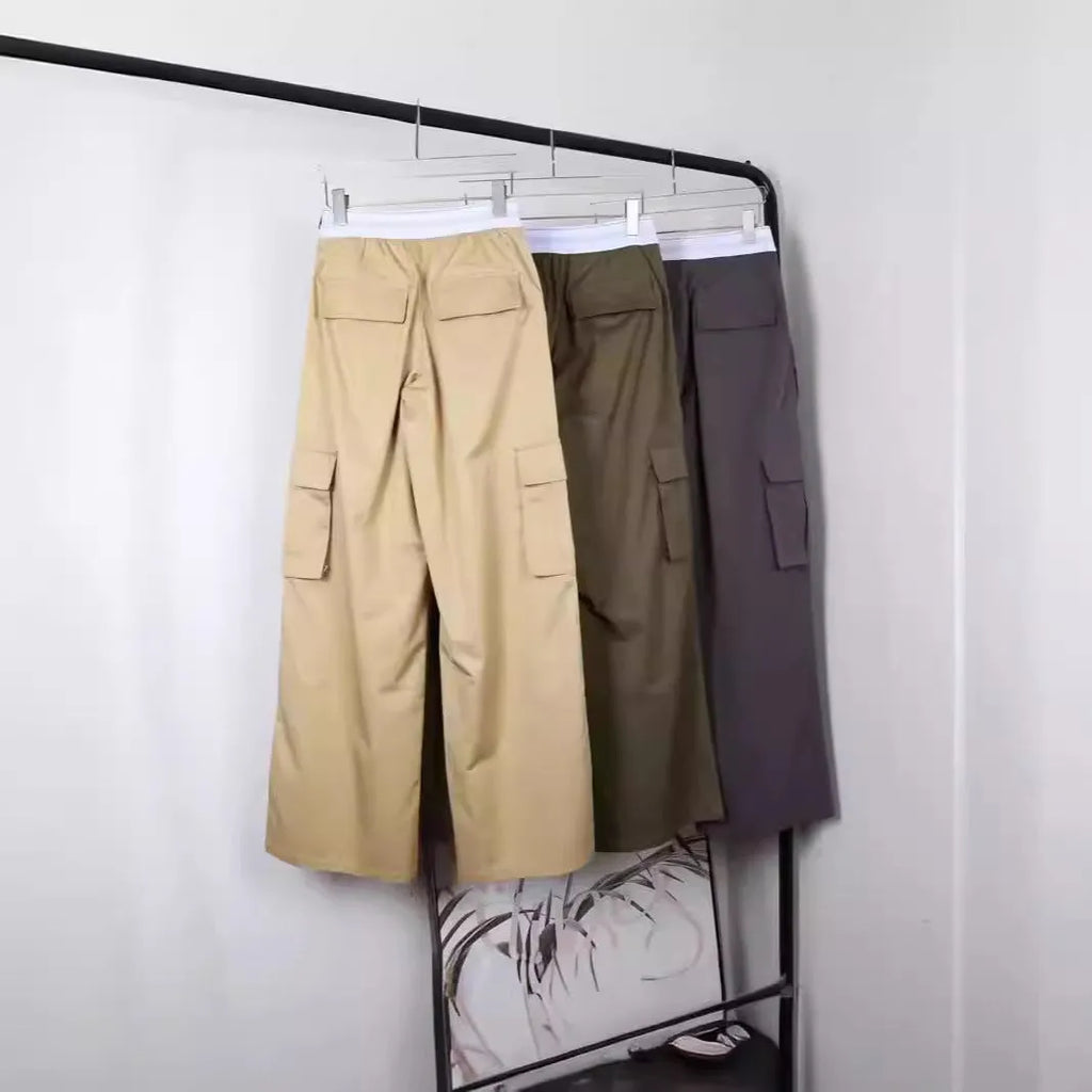 Elastic waistband loose straight cotton trousers in khaki, army green, and gray on a flat lay