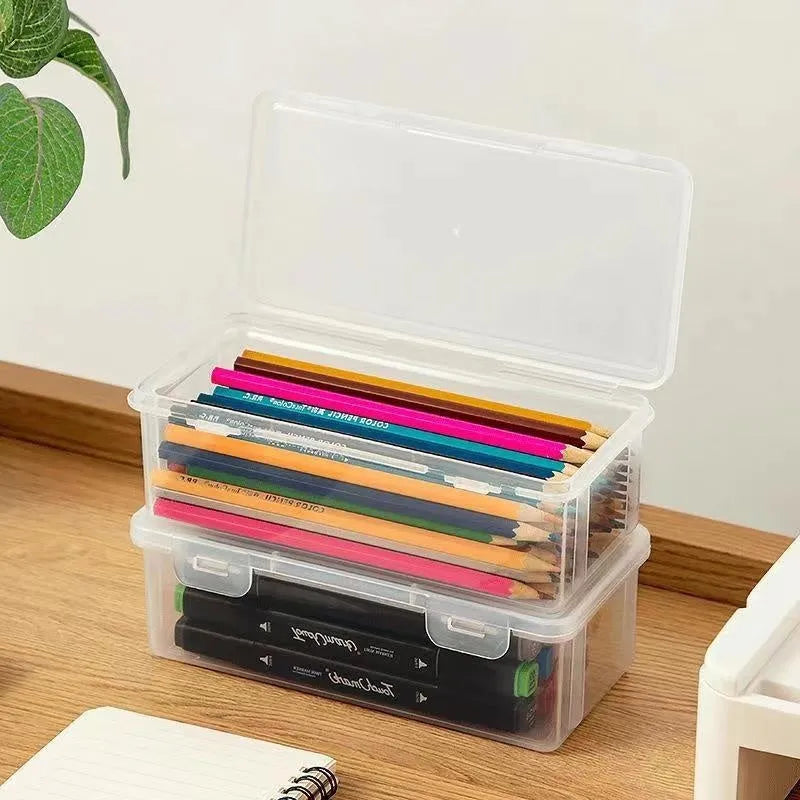 Clear transparent plastic storage box filled with coloured pencils and crayons with lid open.