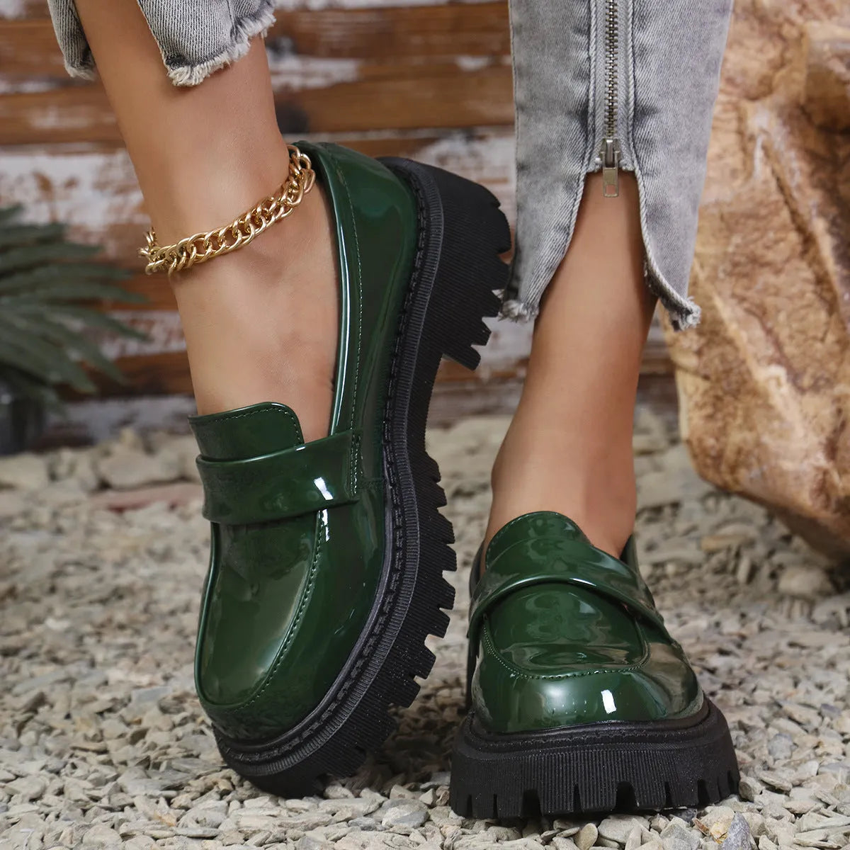 Women's black slip-on loafers with a chunky rubber sole and thick platform heel.