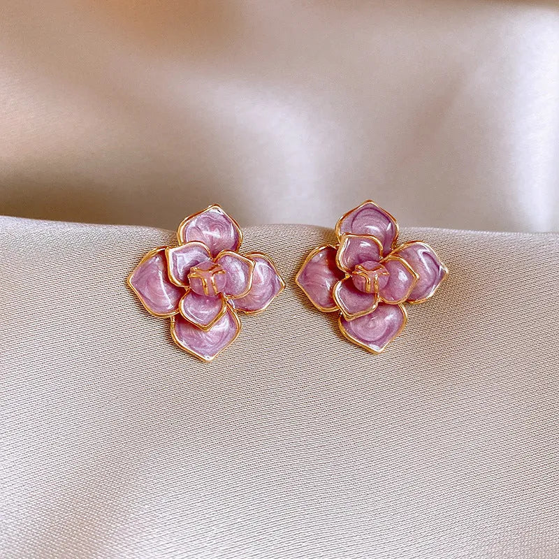 A pair of gold-plated flower stud earrings with a detailed purple oil-spot glaze finish on the petals.