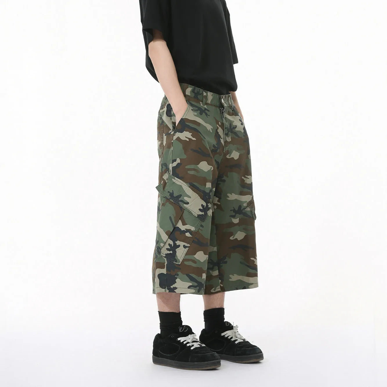 Men's cotton camouflage wide-leg cargo trousers with cropped length on a neutral background.