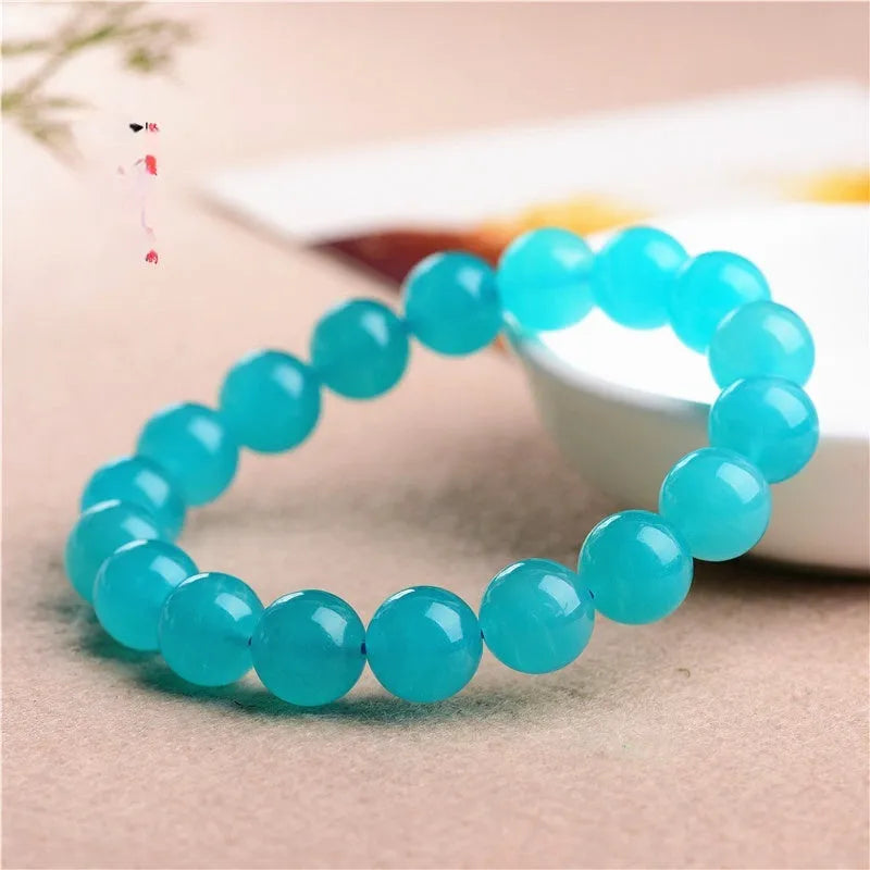 Loose natural blue-green Amazonite beads in various sizes from 6mm to 13mm on a white surface.