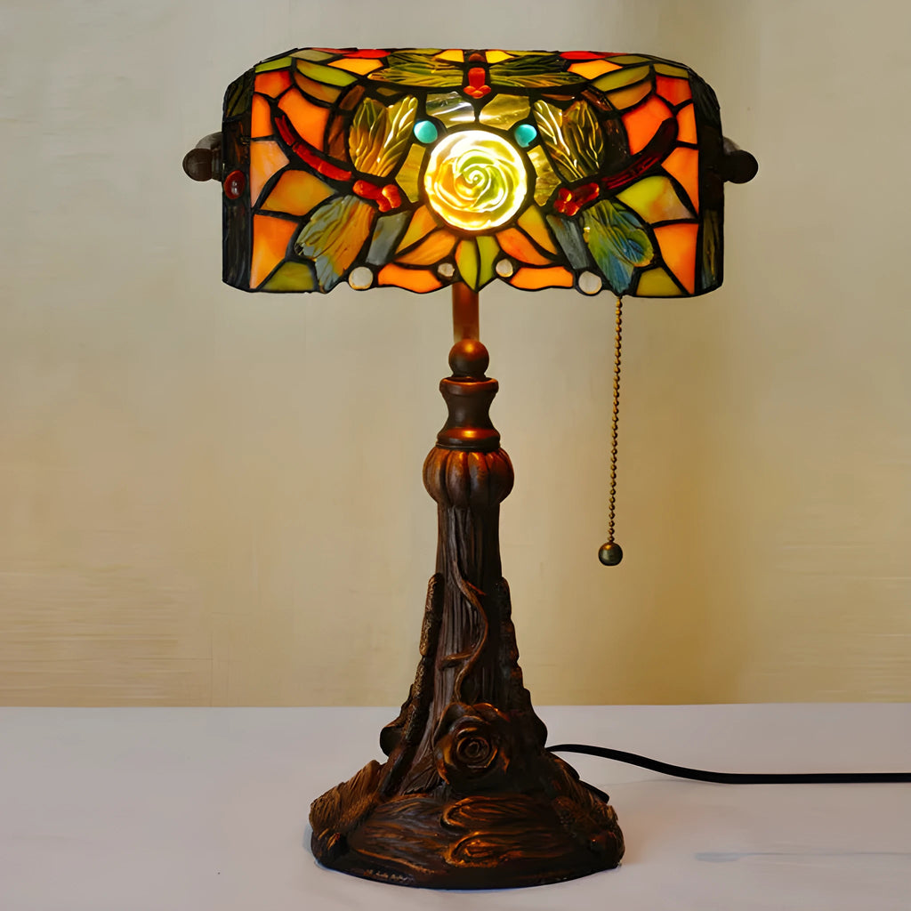A 10-inch tall Tiffany-style table lamp with a stained glass shade on a resin base, shown on a desk.
