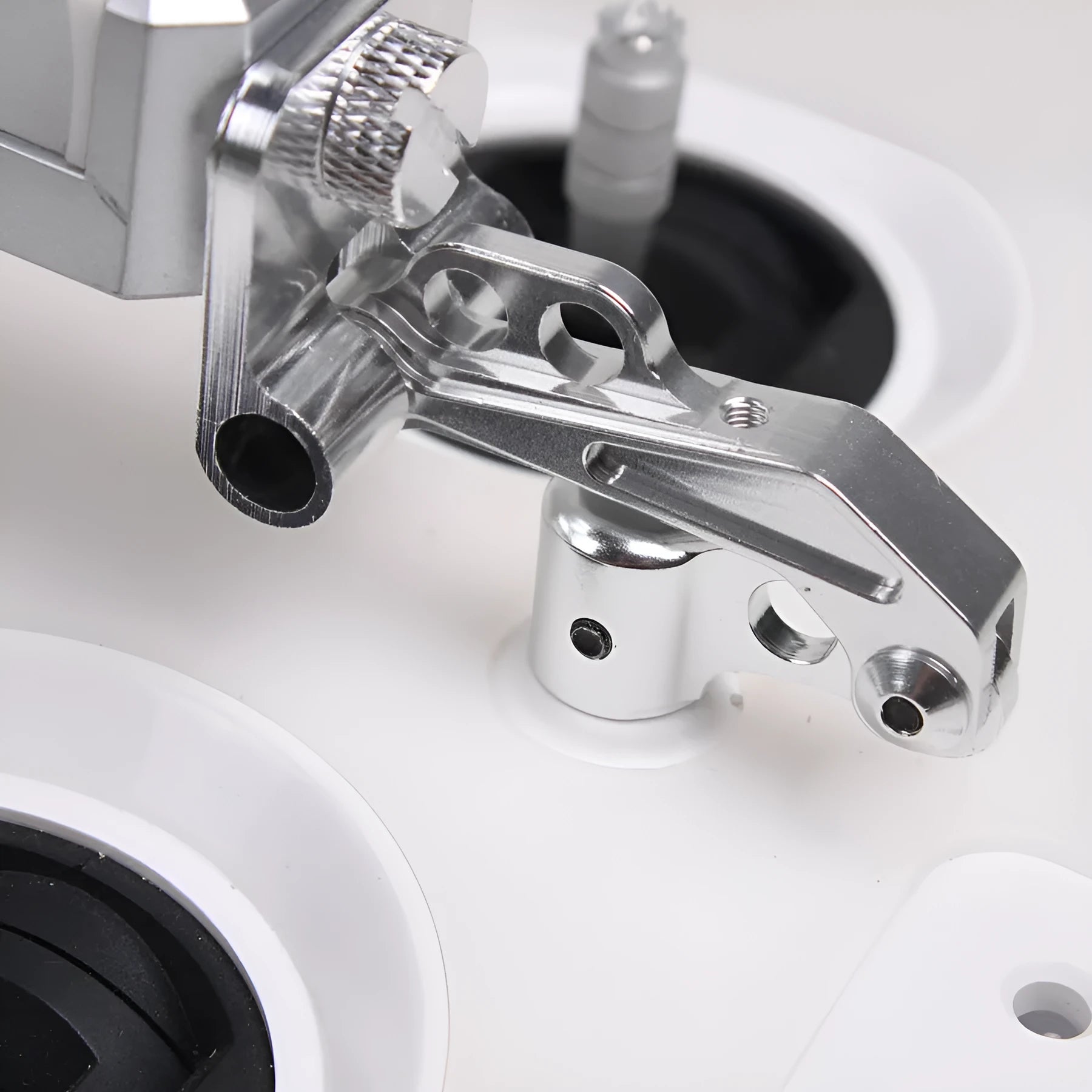 Silver mobile phone holder tongs with a remote control lanyard, a car accessory for elderly users.