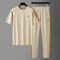 Men's blue ice silk style short sleeve suit top and trousers laid flat.