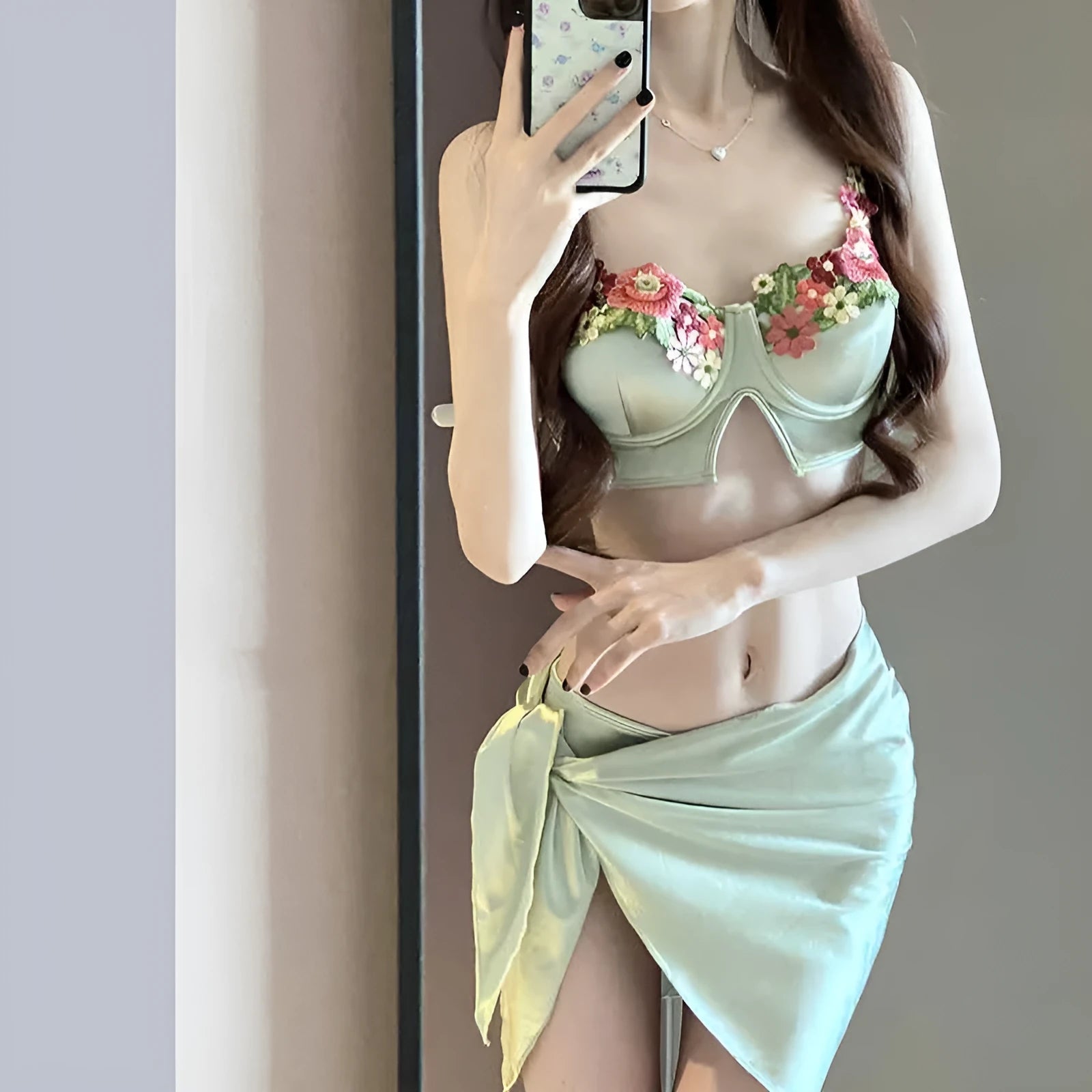 Green women's three-piece bikini set showing triangle top, briefs, and matching skirt on a white background.