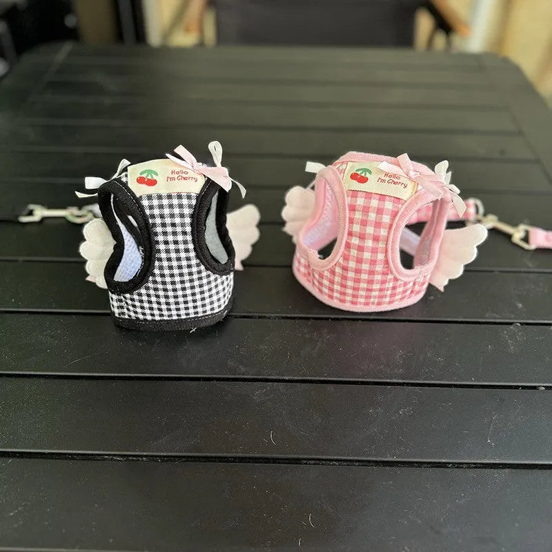 Pink and black cotton chest and back harness with rope leash for a small dog on a white background.