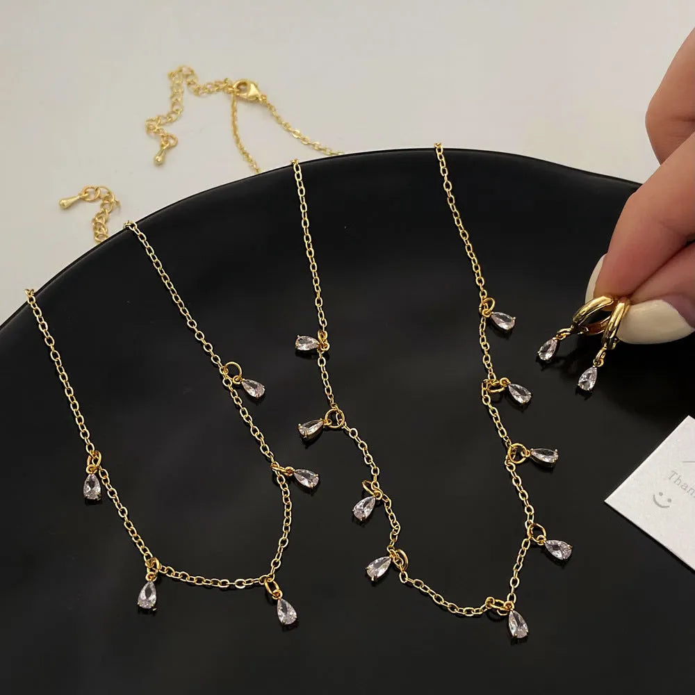 Women's zircon necklace, earrings, and anklet set with geometric pendant on a regular chain.