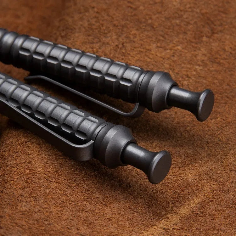 Gunmetal grey titanium alloy tactical pen with push-action decompression mechanism