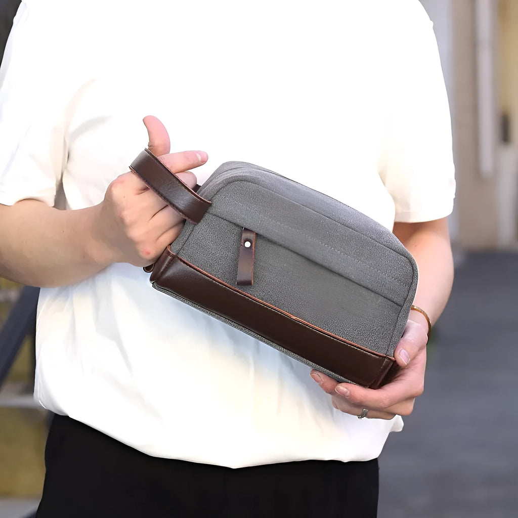 Men's canvas changing wallet in horizontal square shape with soft carry handle and zippered compartments, available in five solid colours.