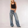 Blue loose straight wide leg cotton trousers with low waist and stitching detail on a model.