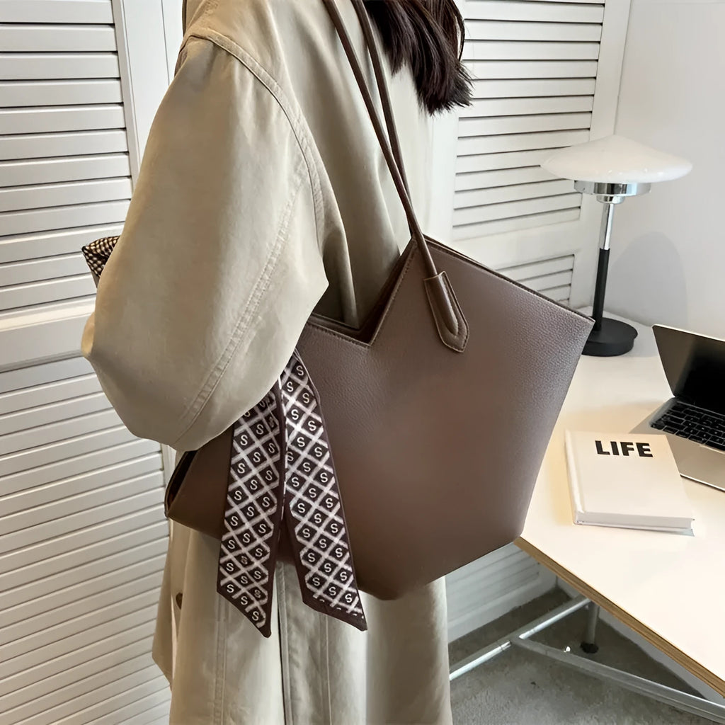 Women's large beige PU leather shoulder bag showing its horizontal square shape and front sandwich pocket.