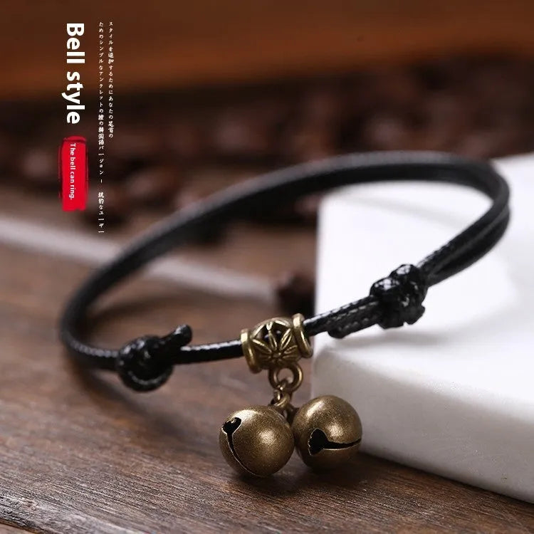 Adjustable nylon rope dog collar with brass bell, shown in black colour on a size guide