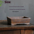 Rectangular purple sand bonsai pot with rustic firewood-burned texture, shown empty on a wooden surface.