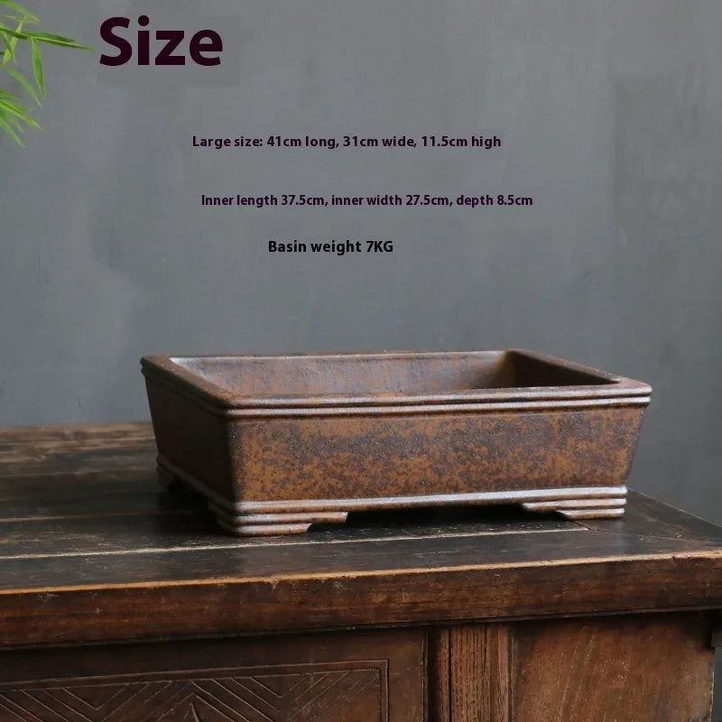Rectangular purple sand bonsai pot with rustic firewood-burned texture, shown empty on a wooden surface.