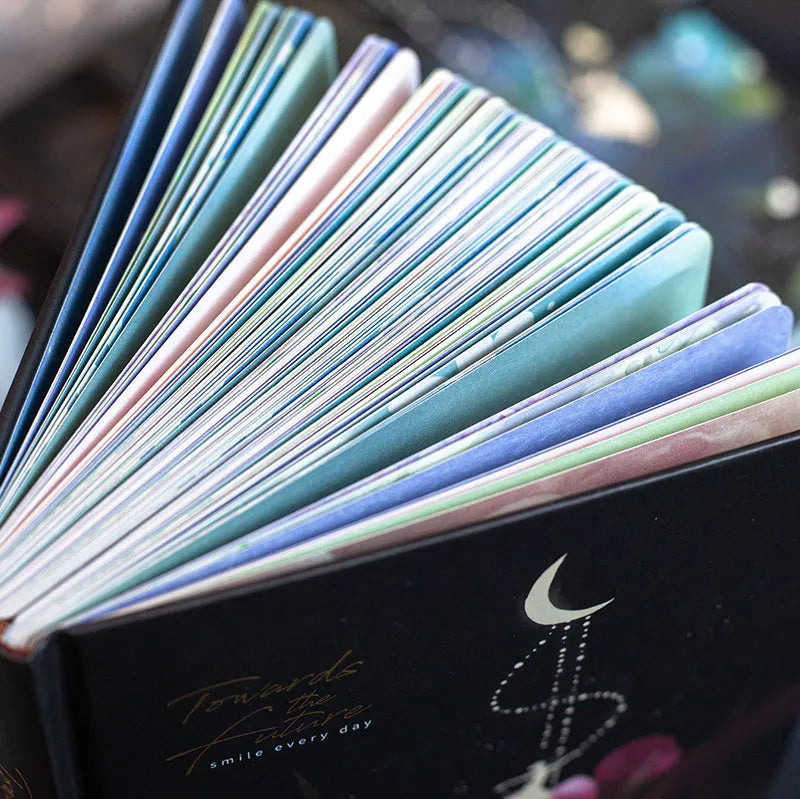 A5 spiral-bound notebook with a luminous coloured cover, open to show lined pages with colour illustrations.