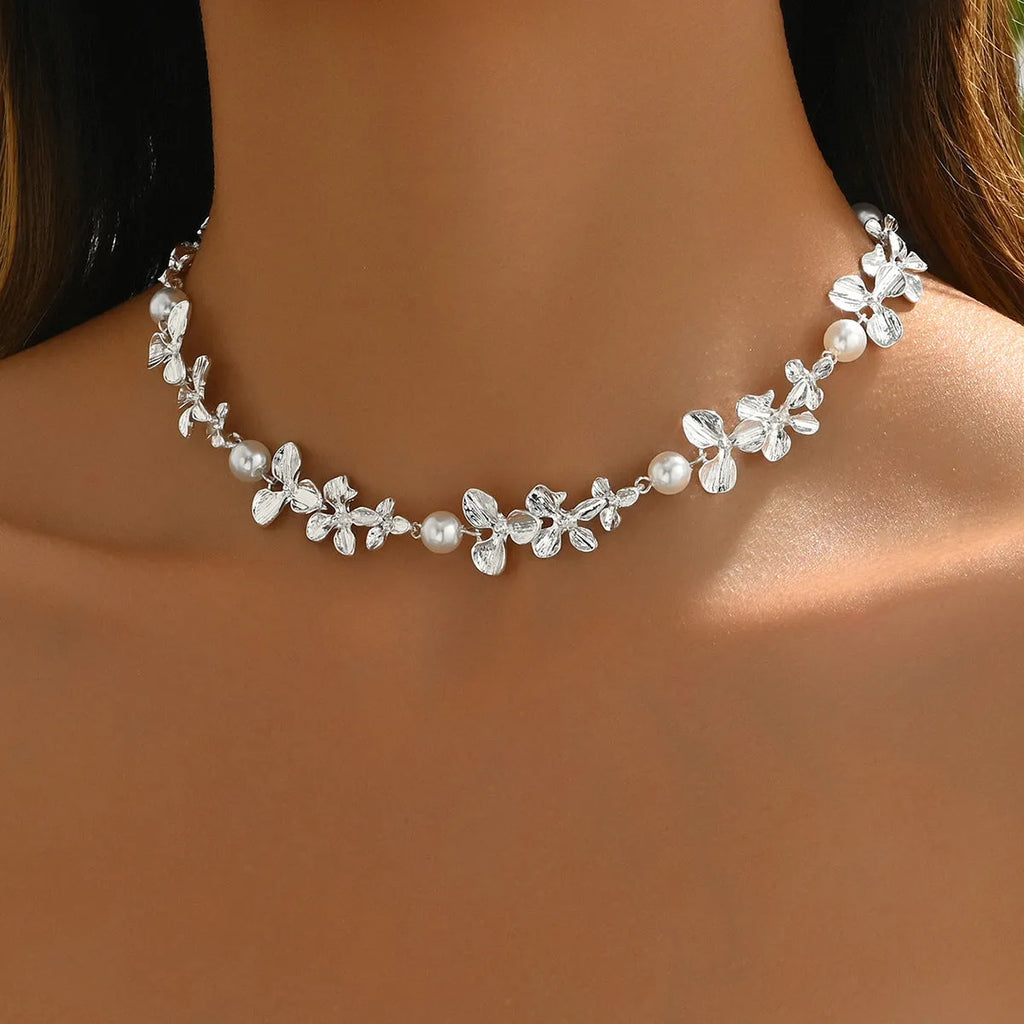 Bright silver alloy flower pearl curved needle clavicle necklace on neutral background