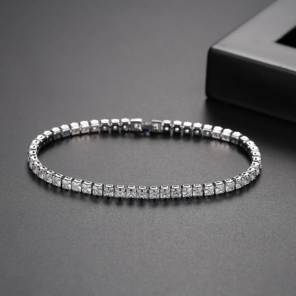 Women's copper tennis bracelet with geometric open-work design and cubic zirconia in gold finish on a light background