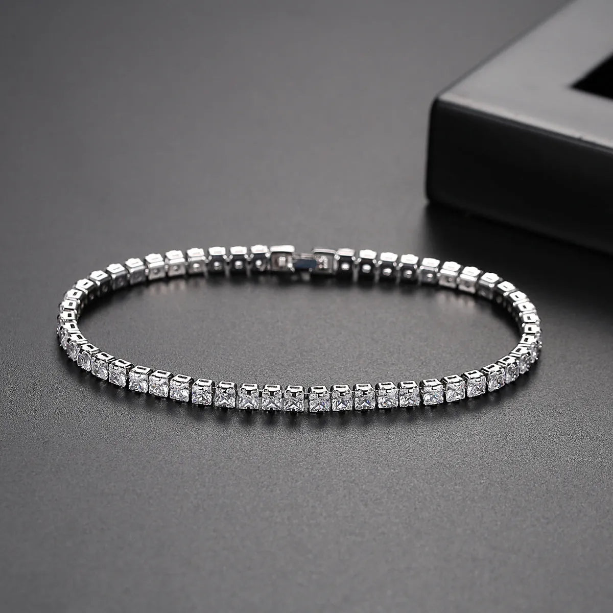 Women's copper tennis bracelet with geometric open-work design and cubic zirconia in gold finish on a light background