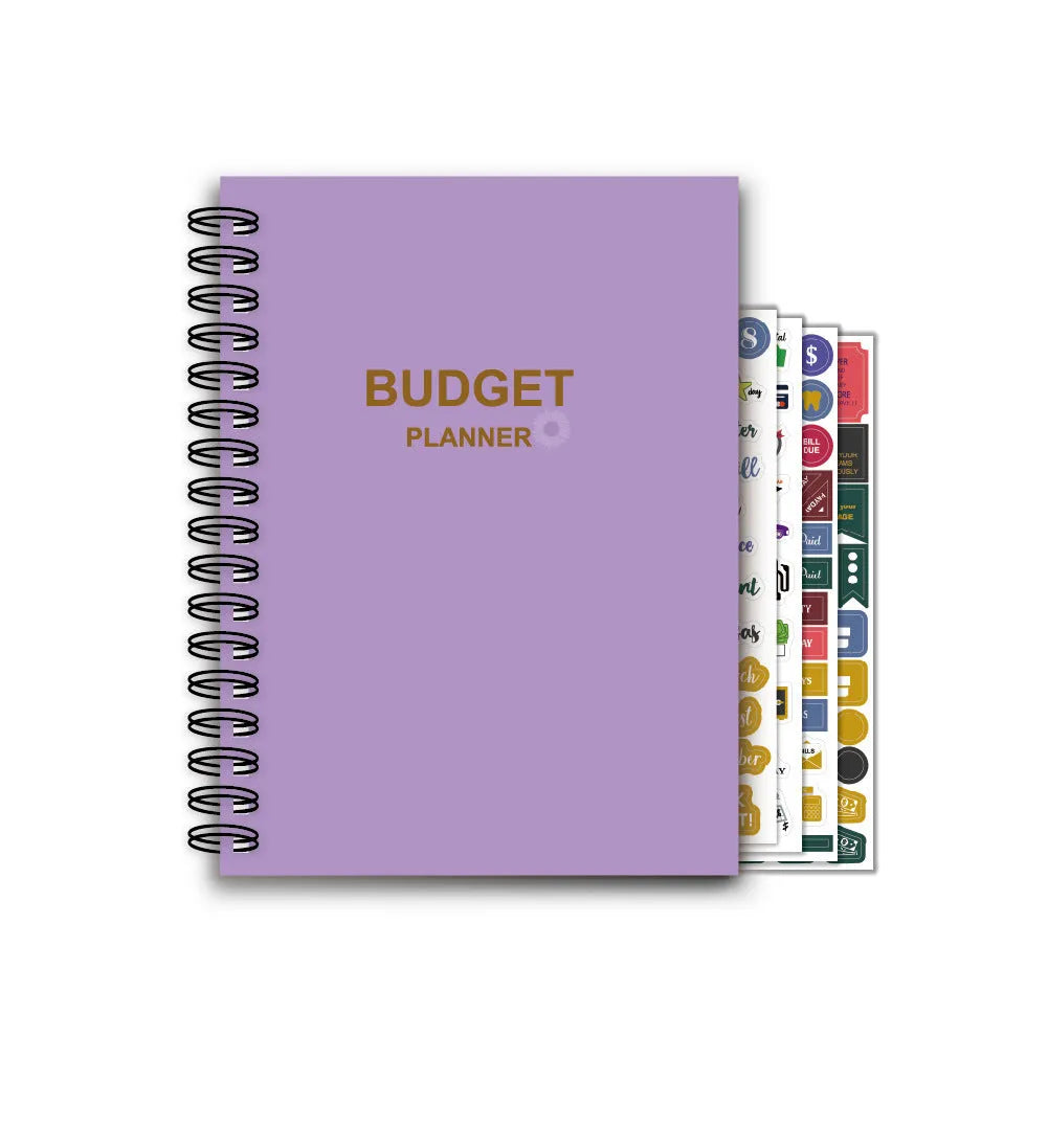 J12 purple coil-bound financial planning notebook with pen, stickers, and paper clips on a desk.