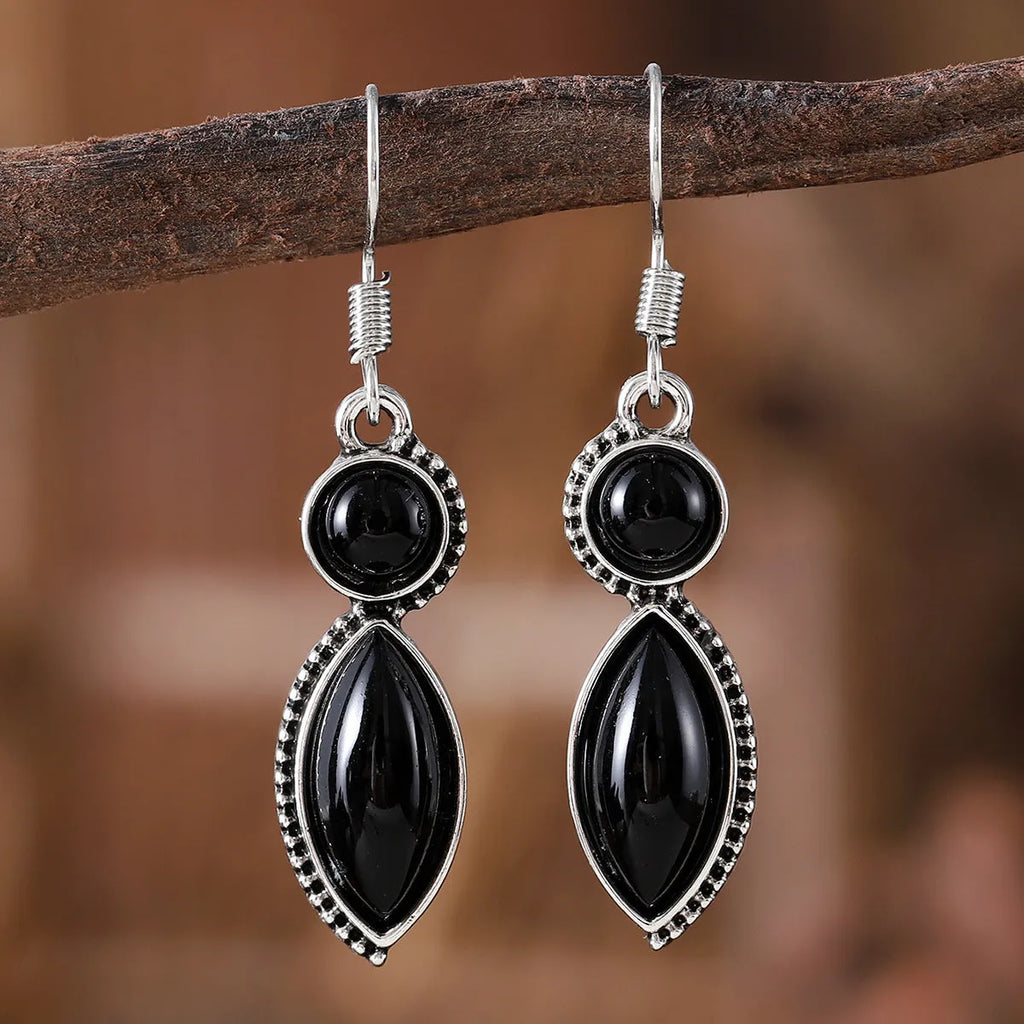 A pair of vintage-style geometric pendant earrings with purple and black stones on a zinc alloy frame.