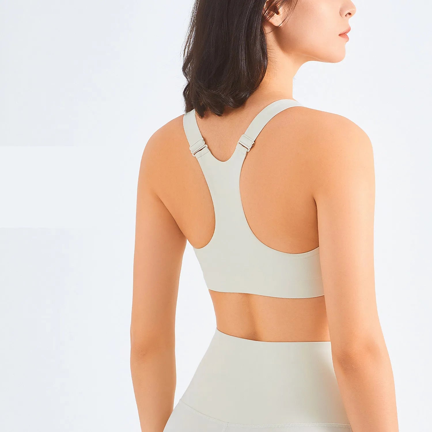Zip front sports bra in pink lychee colour showing racerback shape and mesh back panel