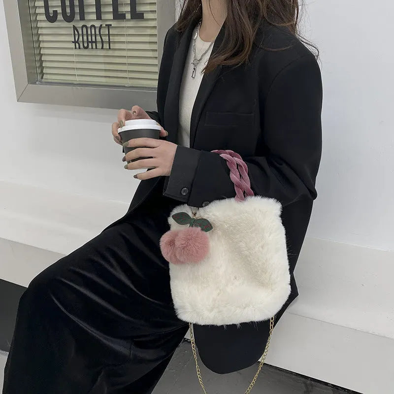 Large capacity soft plush bucket bag in beige with open outer pocket and single shoulder strap