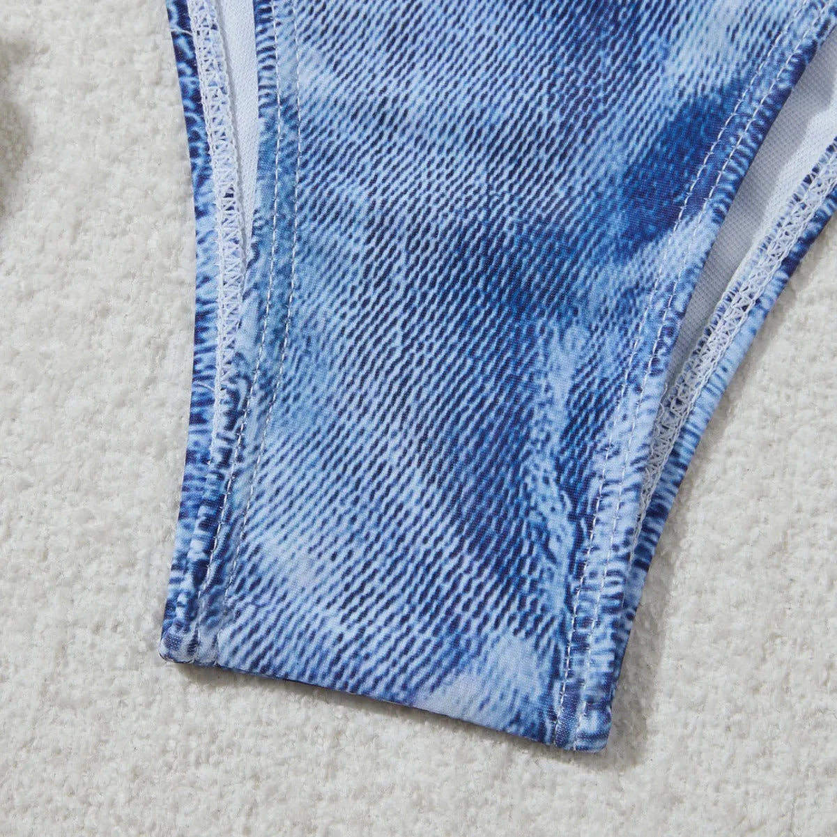 Women's denim blue printed bikini set with adjustable straps laid flat.