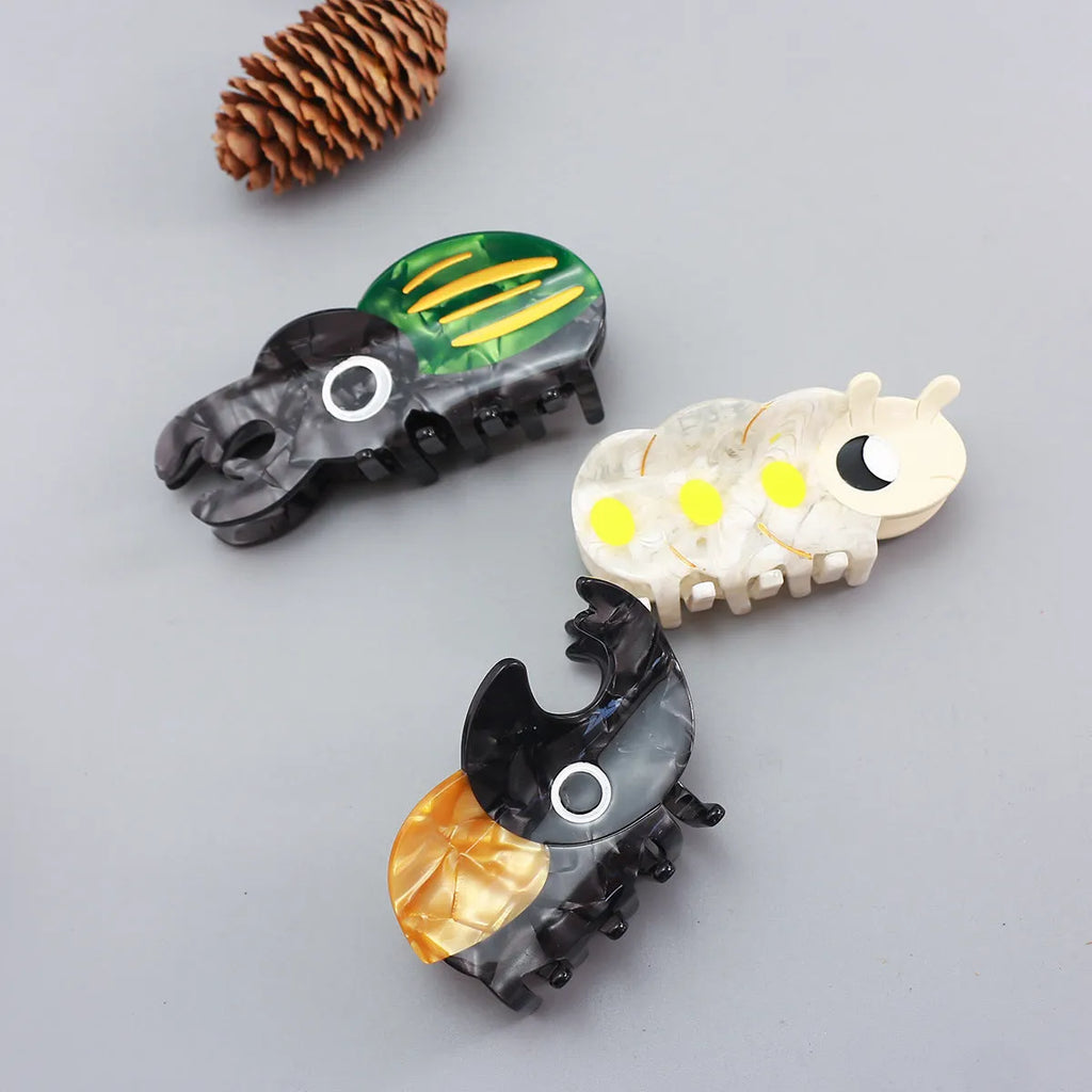Handmade green cartoon beetle grip made from cellulose acetate sheet holding papers.