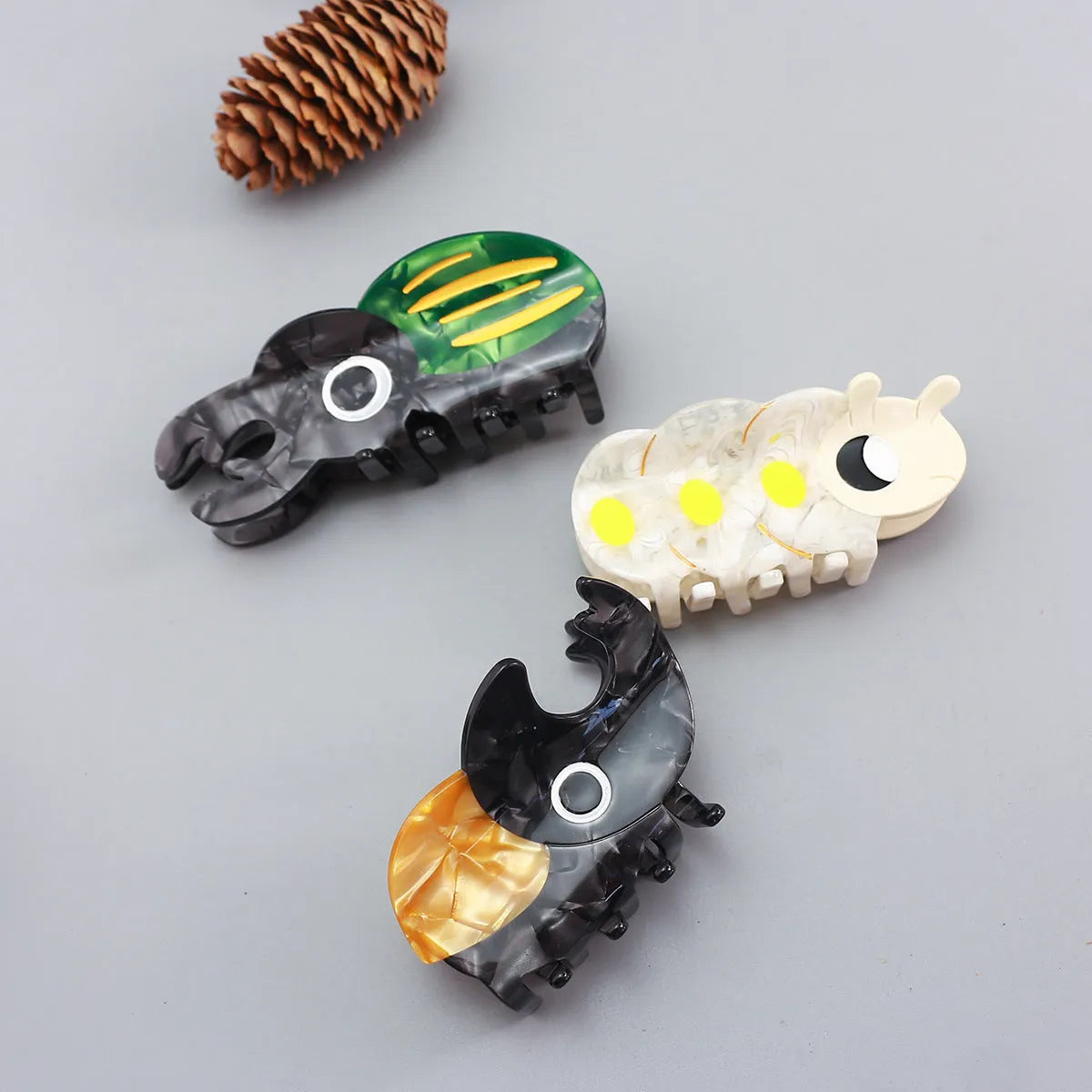 Handmade green cartoon beetle grip made from cellulose acetate sheet holding papers.