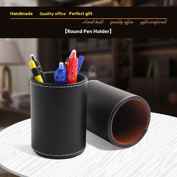 Small round black leather pen holder on a desk.