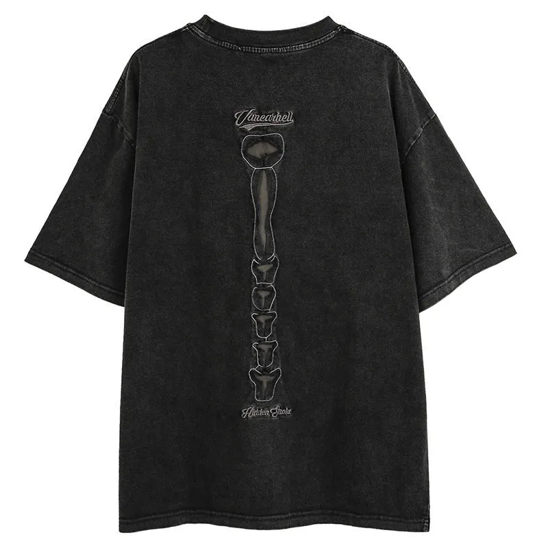 Man wearing a black loose-fit cotton pullover with a large skull and letter graphic on the front, showcasing drop-shoulder sleeves.