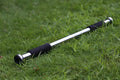Steel adjustable pull-up bar extended in a home doorway for upper body workouts.
