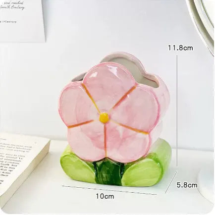 Ceramic floral pen holder box in pink tulip design on a desk.