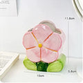 Ceramic floral pen holder box in pink tulip design on a desk.